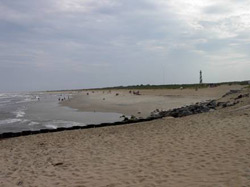 Figure  11.1a. (Cape  Hatteras National Seashore (June 2002). Until it
was  relocated  inland  in 1999, the lighthouse was just to the right of the  stone  groin  in  the  foreground;  it is now about 450 m (1500 ft) inland. (b) [Photo source: �James G. Titus, used with permission].